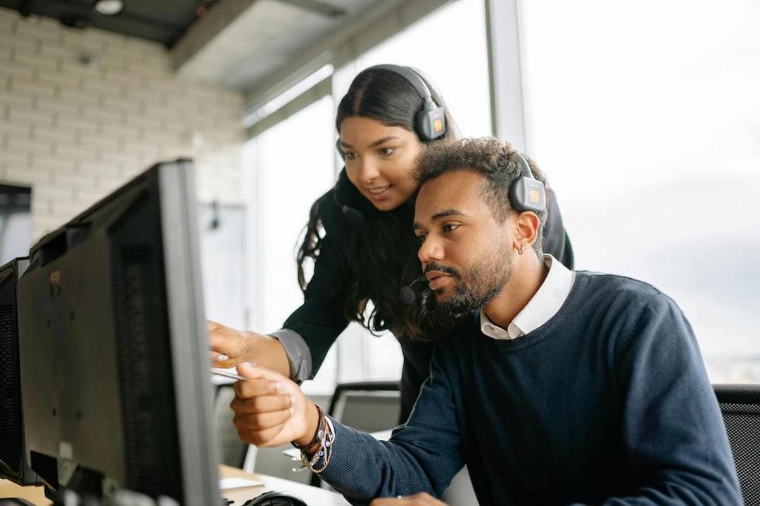 Business Phone - Man and Woman looking at desktop monitor